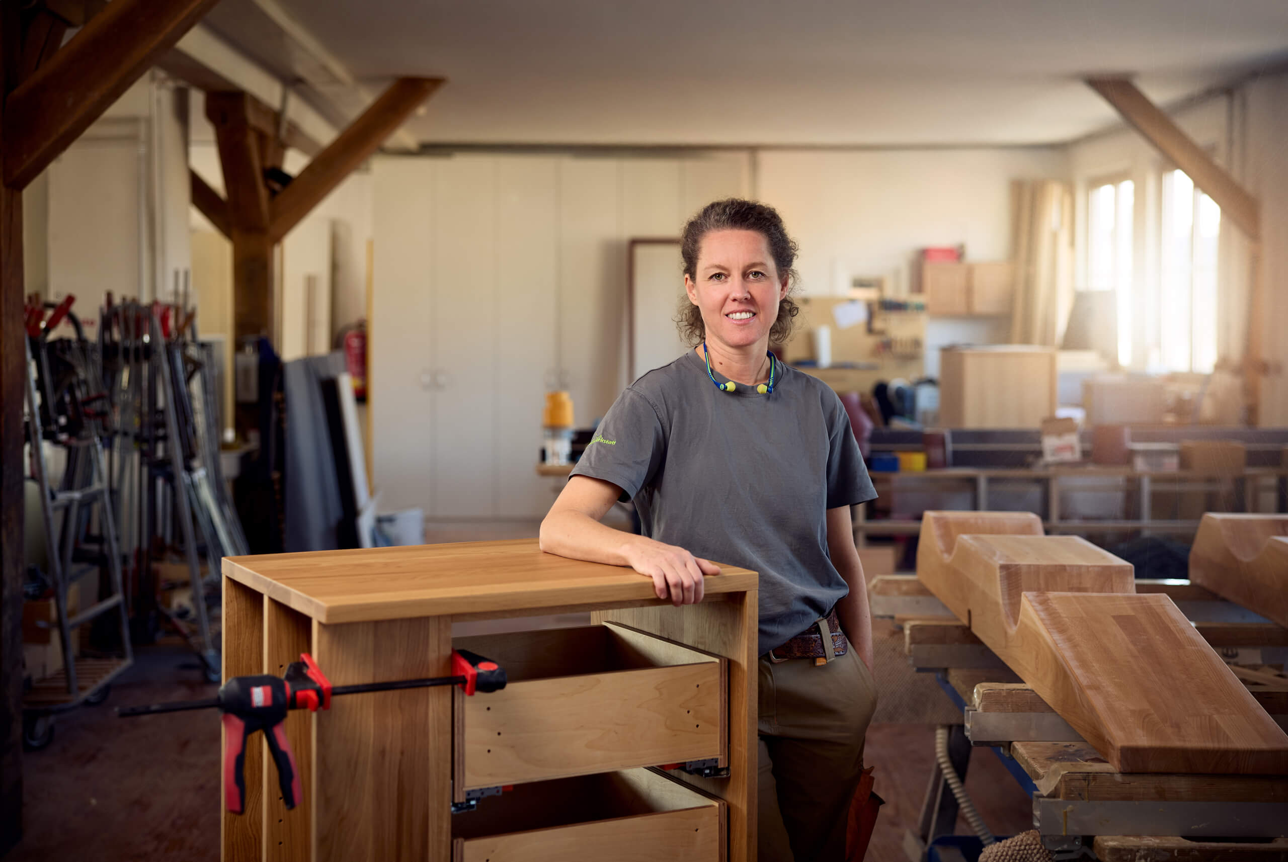 Frau steht in einer Holzwerkstatt.